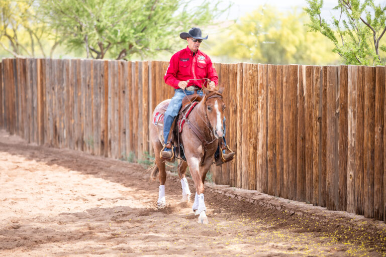 Brad Barkemeyer riding his cow horse next to a fence working on his stop drill.