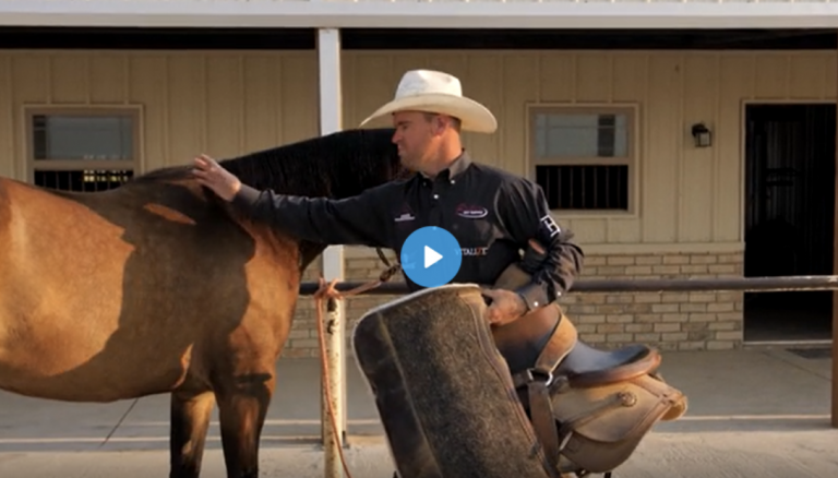 Miles Baker saddling a horse