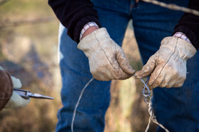 Cattleman fixing fence on the beef cattle ranch