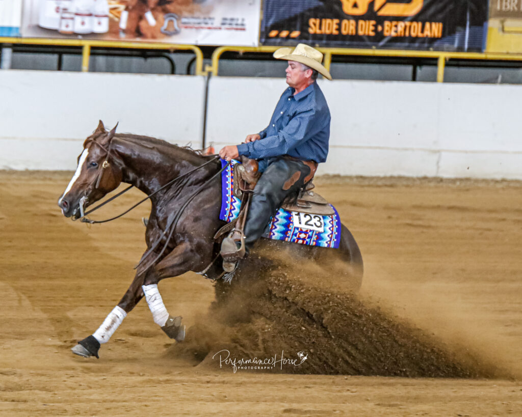 Shane Brown, a recent guest on The Ride Podcast, performing a sliding stop in a reining competition.