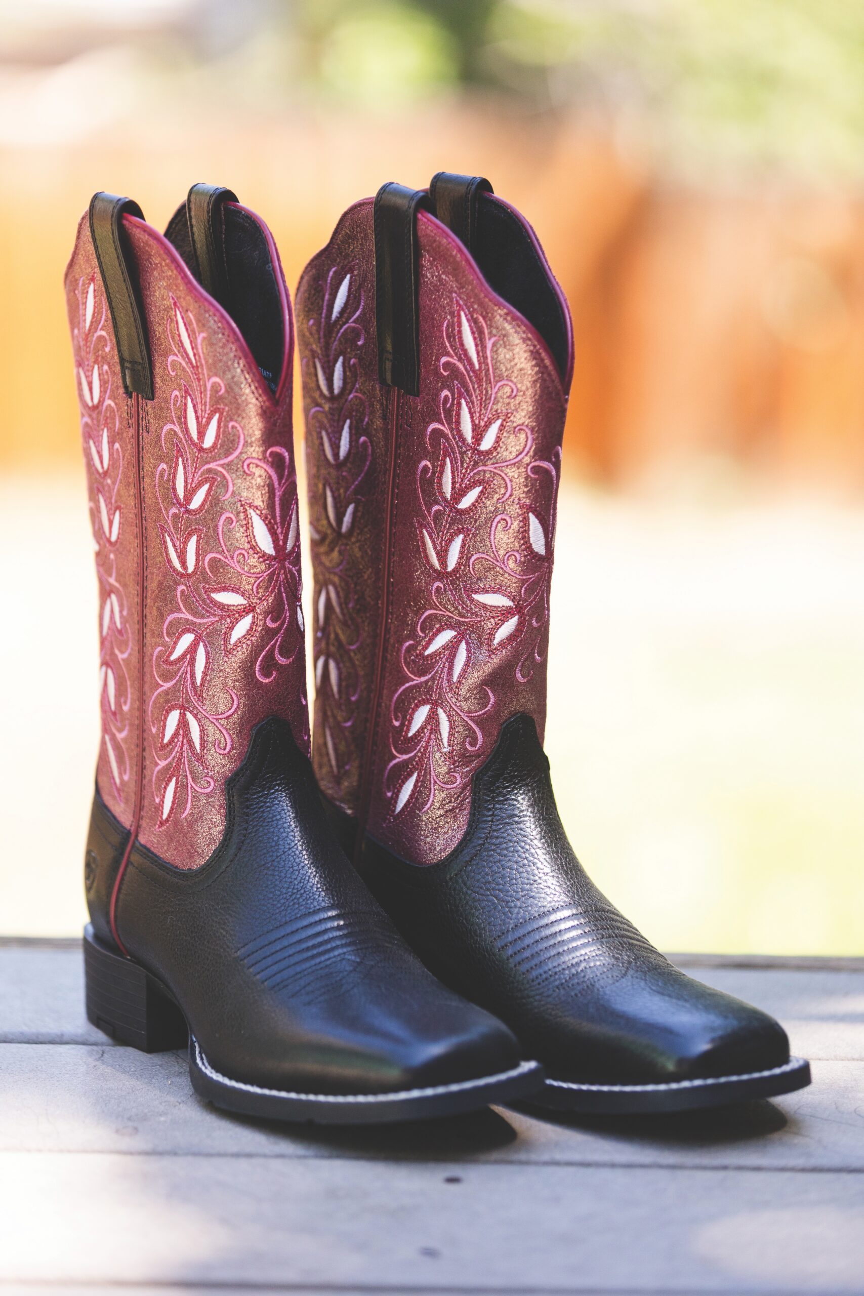 Ariat Western boots with a black foot and a berry-toned embroidered shaft