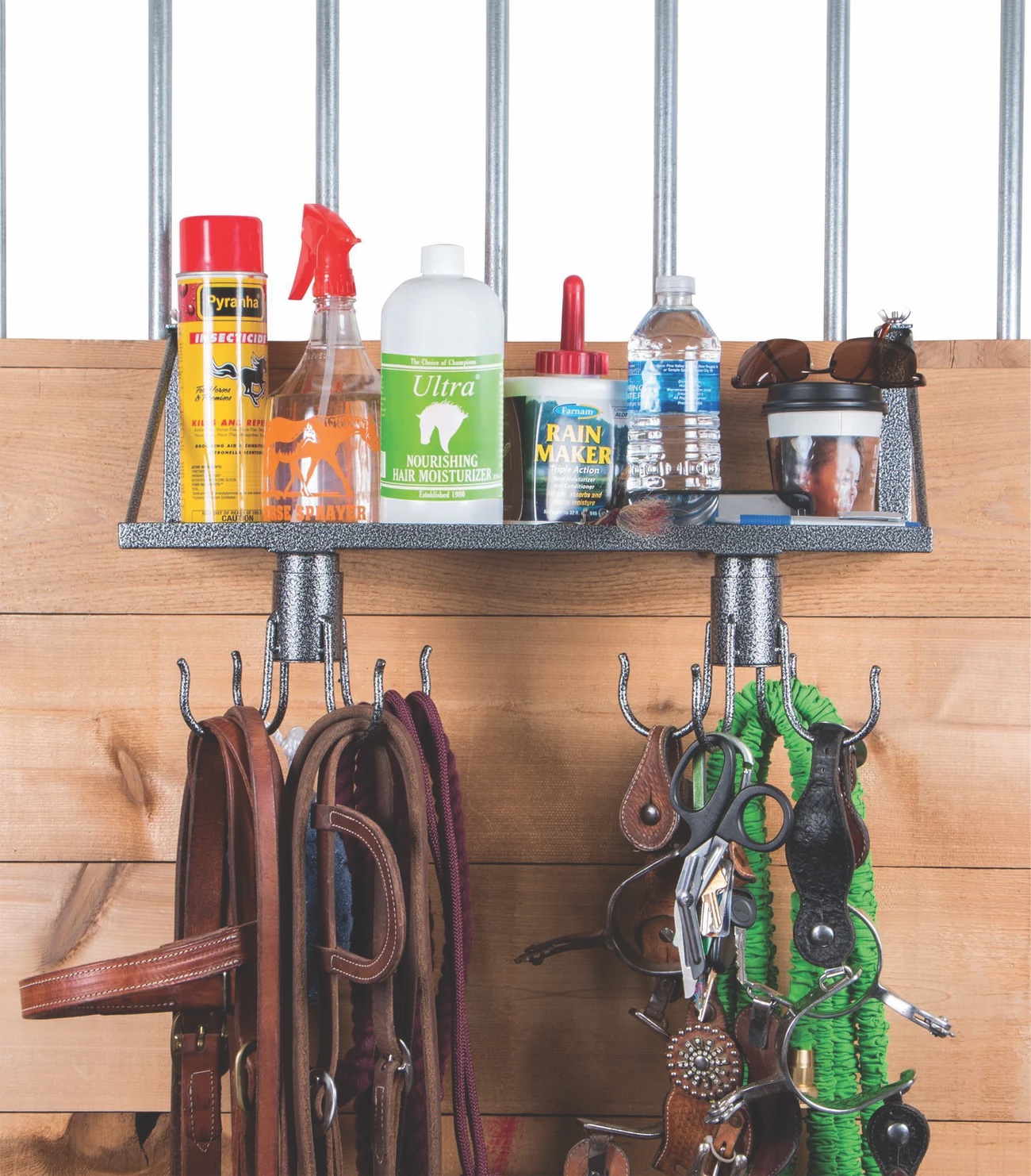 S-Stack portable stall shelf holding grooming sprays and bottles, with swivel hangers below organizing bridles, leads, and spurs.