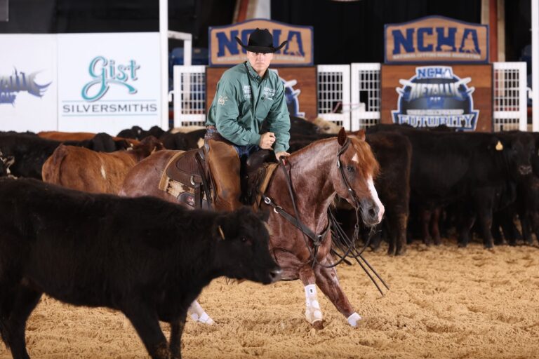 Beau Galyean rides cutting horse Minkish while working a black cow in the arena.