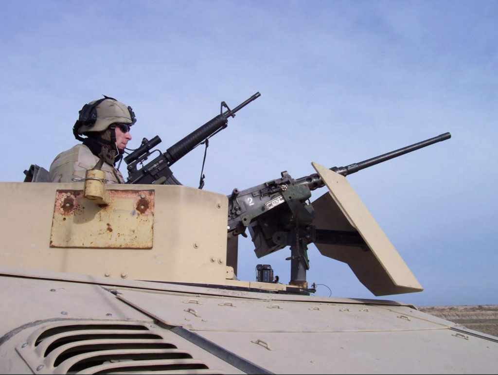 Jeremy Svejcar sits in the gunner’s turret of a tan Humvee during his Army deployment.